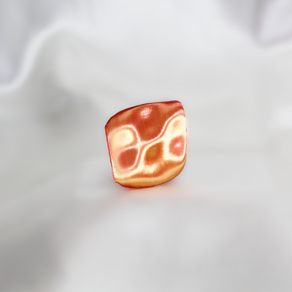 Bacon-shaped ring on a white fabric background
