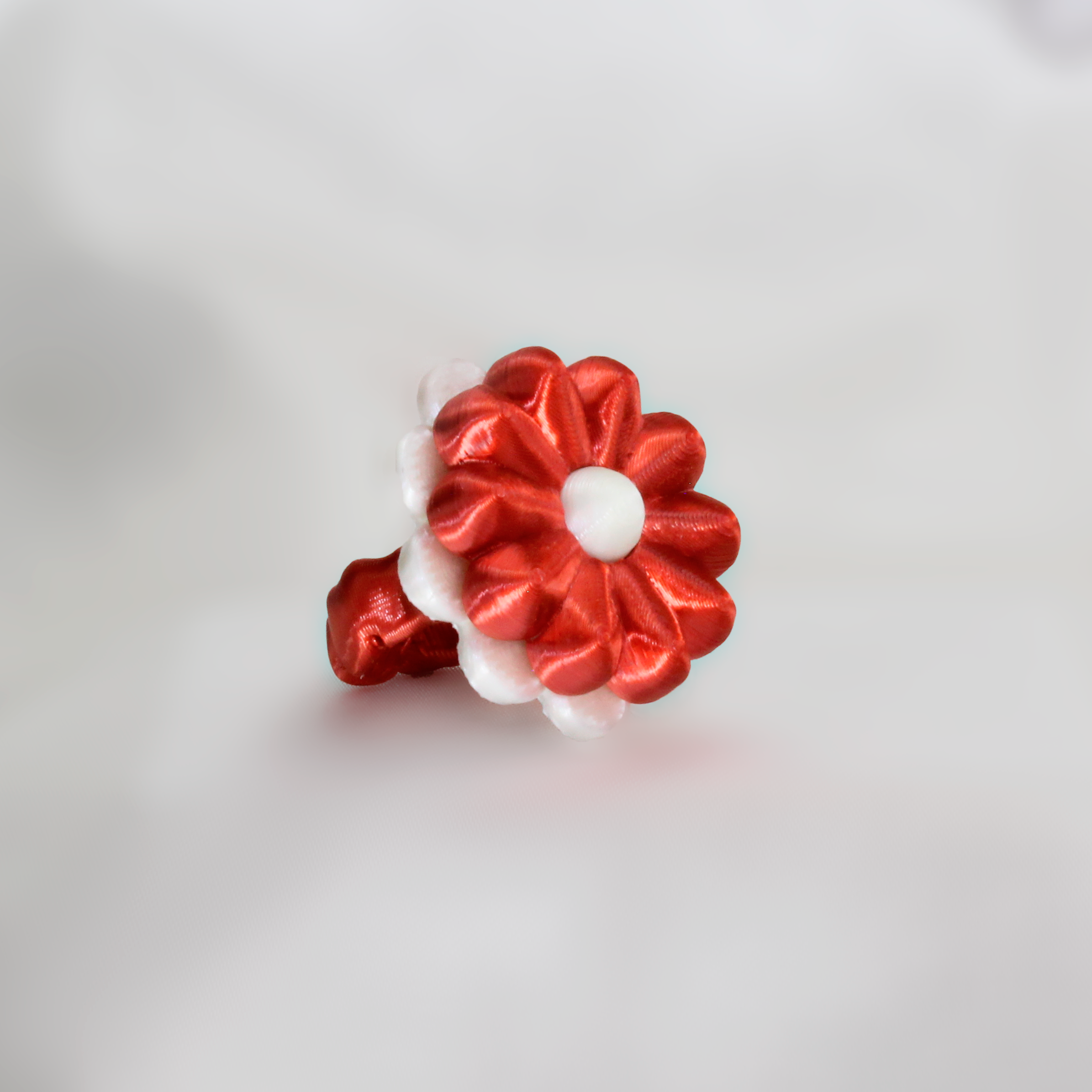 Red and white decorative flower on a white fabric background