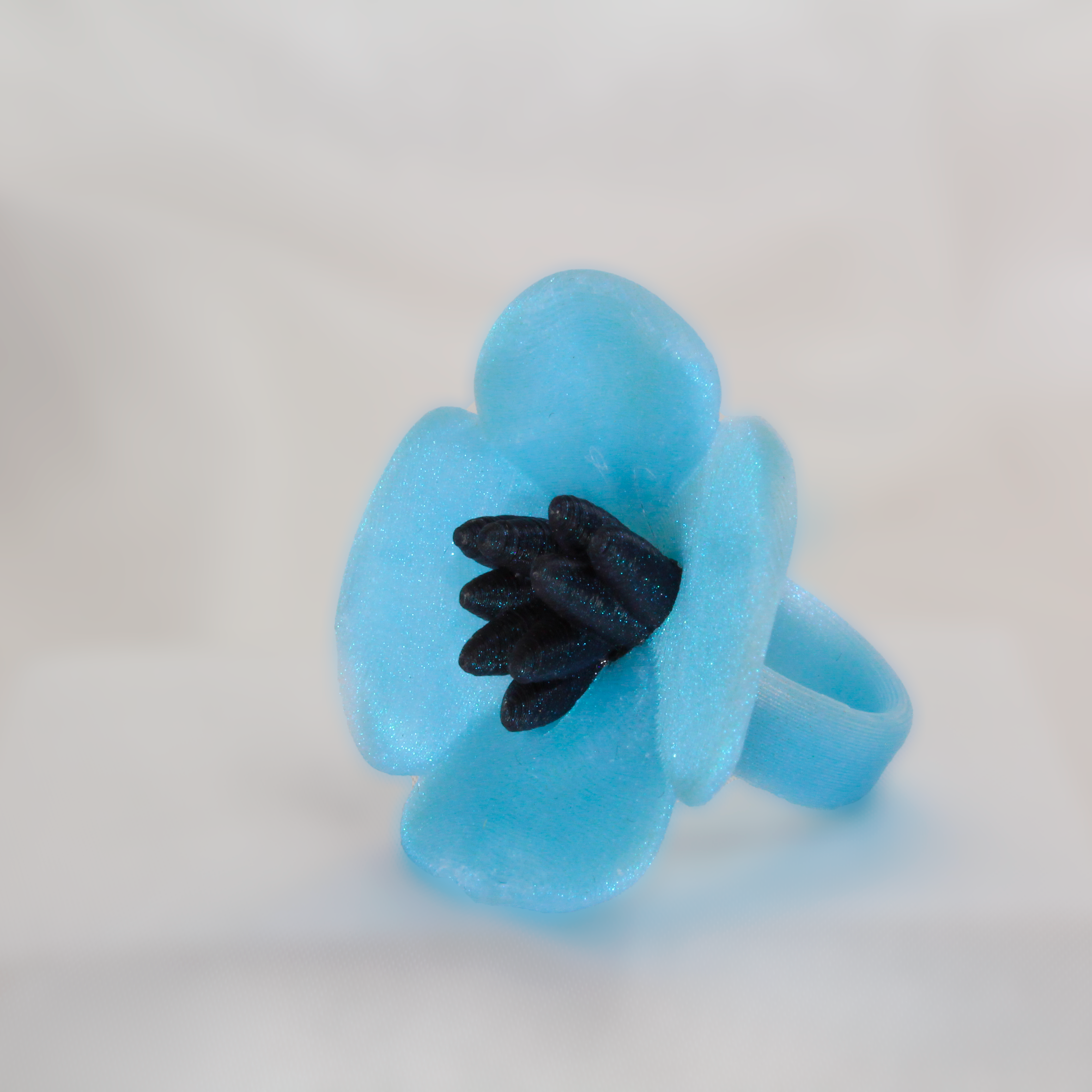 Blue flower-shaped object with a black center on a white background
