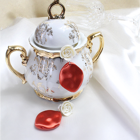 Decorative teapot with floral and heart designs on a white background